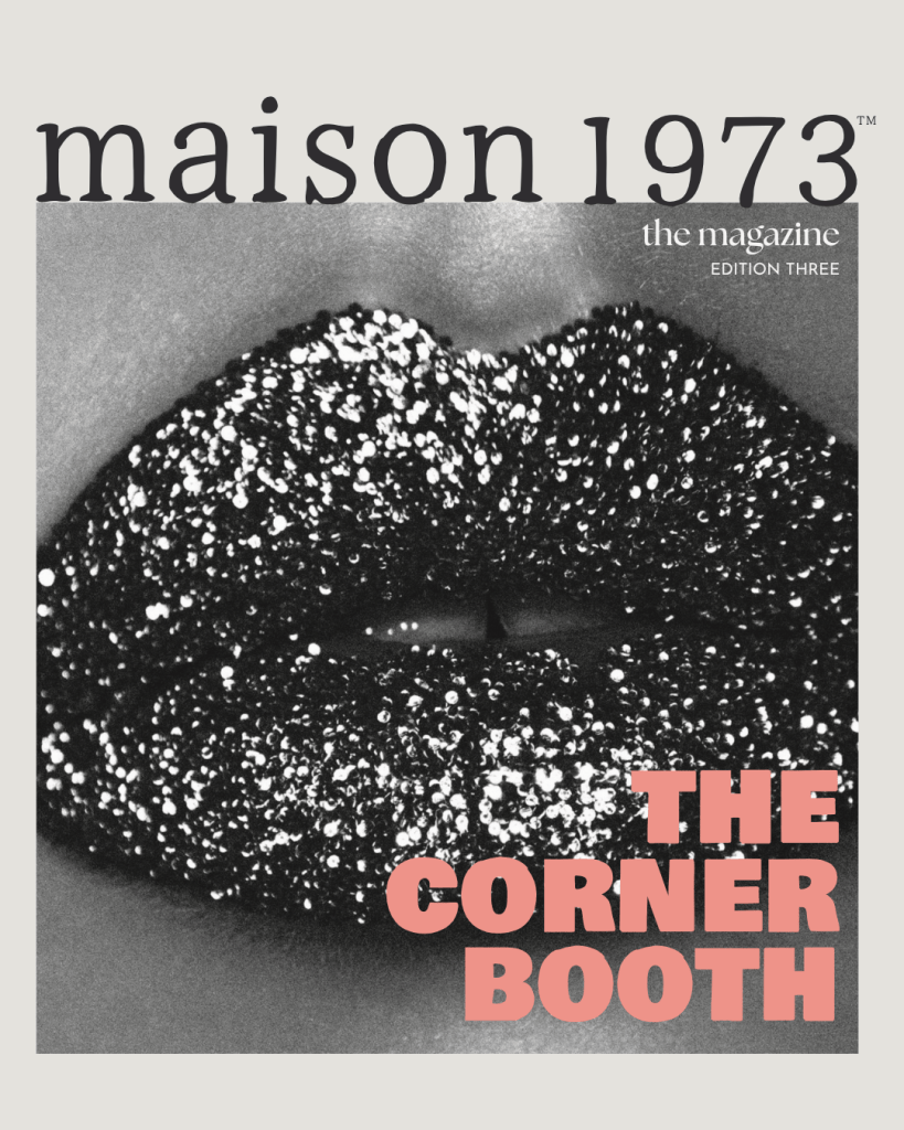 Black and white close-up image of glittery lips with the text 'THE CORNER BOOTH' in pink, featured on the cover of 'maison 1973' magazine, edition three.